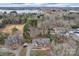 Aerial shot showcasing a home with a landscaped yard and lake views in the distance, surrounded by trees at 2201 Holly Ln, Shelby, NC 28150