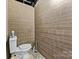 Basement half-bathroom features a standard toilet and wood-paneled walls at 24253 Old Aquadale Rd, Albemarle, NC 28001