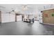 Open concept garage space for dining and storage with white walls and garage doors at 24253 Old Aquadale Rd, Albemarle, NC 28001