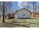 View of the home's back exterior with a combination of siding and brick, surrounded by trees and gravel landscaping at 259 Unionville Indian Trail W Rd, Indian Trail, NC 28079