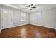 Bright bedroom with hardwood floors, a ceiling fan, and two windows, offering a peaceful retreat at 259 Unionville Indian Trail W Rd, Indian Trail, NC 28079