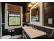 Modern bathroom with dark walls, a marble sink, stylish fixtures, and a bright window with nature views at 311 3Rd Avenue Se Dr, Hickory, NC 28602