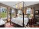 Spacious bedroom with a canopy bed, warm lighting, and windows providing natural light and views at 311 3Rd Avenue Se Dr, Hickory, NC 28602