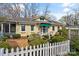 Inviting yellow home featuring a white picket fence and established landscaping at 311 3Rd Avenue Se Dr, Hickory, NC 28602