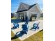 Community area with Adirondack chairs and an open-air pavilion strung with market lights at 3237 Vermillion Dr, Harrisburg, NC 28075