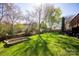 Fenced backyard, green grass, wooden fence, garden beds, with trees at 3329 Brownes Creek Rd, Charlotte, NC 28269