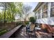 Back deck with wooden chairs and table surrounded by a lush green backyard with trees at 3329 Brownes Creek Rd, Charlotte, NC 28269