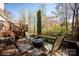 Outdoor living space featuring wooden chairs, table, fire pit, and a view of backyard landscaping at 3329 Brownes Creek Rd, Charlotte, NC 28269