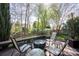 Wooden patio with a table, chairs, fire pit, and a backdrop of lush trees and landscaping at 3329 Brownes Creek Rd, Charlotte, NC 28269