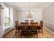 Dining room with hardwood floors, a wooden table, and natural light filtering through sheer curtains at 3329 Brownes Creek Rd, Charlotte, NC 28269