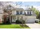 Inviting two-story home with a brick and siding exterior, a well-maintained lawn, and blossoming trees in the yard at 3329 Brownes Creek Rd, Charlotte, NC 28269