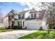 Charming two-story home featuring a well-manicured lawn, blossoming trees, and an attached two-car garage at 3329 Brownes Creek Rd, Charlotte, NC 28269