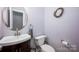 Bright powder room featuring a modern vessel sink, round mirror, and decorative wreath at 3329 Brownes Creek Rd, Charlotte, NC 28269