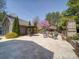 Expansive backyard patio with a dining set, fire pit, and lush landscaping at 371 Montibello Dr, Mooresville, NC 28117