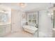 Bright primary bathroom featuring a standalone tub, glass shower, and white cabinetry at 3716 Drayton Hall Ln, Charlotte, NC 28270