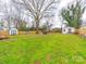 Large backyard with a firepit, storage sheds, and a wooden fence for privacy at 404 Plaza Dr, Harrisburg, NC 28075