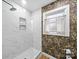Modern bathroom with a glass-enclosed shower, white tile, and bold wallpaper at 404 Plaza Dr, Harrisburg, NC 28075