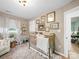 Bedroom showcasing a vintage gold crib, neutral walls adorned with art, and a cozy reading corner at 404 Plaza Dr, Harrisburg, NC 28075