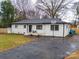 A charming brick home boasts a well-manicured lawn, basketball hoop, and paved driveway at 404 Plaza Dr, Harrisburg, NC 28075