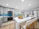 Bright kitchen features a center island with seating, gray cabinets, and a complementary blue backsplash at 404 Plaza Dr, Harrisburg, NC 28075