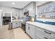Charming kitchen features shaker cabinets, stainless steel appliances, quartz countertops, and blue backsplash at 404 Plaza Dr, Harrisburg, NC 28075