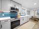 Updated kitchen featuring stainless steel appliances, stylish shaker cabinets, quartz countertops and blue backsplash at 404 Plaza Dr, Harrisburg, NC 28075