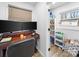 This home office features a dark wood desk with dual monitors, plus ample storage in the pantry at 404 Plaza Dr, Harrisburg, NC 28075