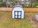 A white shed with black trim sits in the yard, offering extra storage space at 404 Plaza Dr, Harrisburg, NC 28075