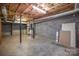 Unfinished basement with concrete floor, exposed pipes, and brick walls at 4421 3Rd Nw St, Hickory, NC 28601