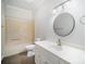 Bright bathroom featuring a vanity with a sink, a round mirror, a toilet and tub/shower combo at 4421 3Rd Nw St, Hickory, NC 28601