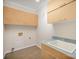 Well-lit laundry room offers upper and lower cabinets, and a stainless steel sink set in the countertop at 4421 3Rd Nw St, Hickory, NC 28601