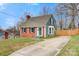 Charming two-story home featuring a brick facade, green siding, and a concrete driveway at 514 3Rd Avenue Se Dr, Hickory, NC 28602