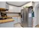 Well-lit kitchen with tile floor, butcher block counters, stainless steel appliances and white cabinetry at 514 3Rd Avenue Se Dr, Hickory, NC 28602