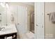 Bathroom featuring double sinks, dark cabinets, shower stall, and ample lighting at 5425 Closeburn Rd # 309, Charlotte, NC 28210