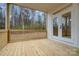 Covered back porch with wooden floors and railing overlooking a wooded backyard at 558 Edmunds Ln # 41, Clover, SC 29710