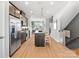 Open-concept kitchen with stainless steel appliances, island seating, and seamless flow into the living spaces at 5640 Kingspan Dr, Charlotte, NC 28217