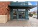 A ground-level entrance with brick sidewalk, an awning, a street, and trees in the background at 626 N Graham St # 211, Charlotte, NC 28202