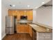 Open kitchen featuring stainless steel refrigerator, cooktop, and granite countertops at 710 W Trade St # 309, Charlotte, NC 28202