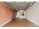 Open-concept living room featuring exposed brick, staircase, and hardwood floors at 710 W Trade St # 309, Charlotte, NC 28202