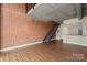 Open-concept living room featuring exposed brick, staircase, and hardwood floors at 710 W Trade St # 309, Charlotte, NC 28202