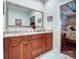 Bathroom with wood vanity, double sinks, granite counters, and large mirror at 8146 Viscount Ct, Denver, NC 28037