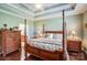 Spacious bedroom features a four-poster bed, light green walls, and wood flooring at 8146 Viscount Ct, Denver, NC 28037