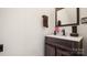 Modern bathroom with a dark wood vanity, white countertop, and stylish mirror at 8534 Loxton Cir, Charlotte, NC 28214