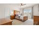 Cozy bedroom featuring a large window, ceiling fan, and classic wood furnishings at 8534 Loxton Cir, Charlotte, NC 28214
