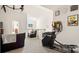 Bright bonus room featuring an elliptical machine, PacMan arcade game, and comfortable leather seating at 8534 Loxton Cir, Charlotte, NC 28214