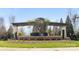Landscaped community entrance featuring a stone structure, pergola, manicured shrubs, and vibrant greenery at 8534 Loxton Cir, Charlotte, NC 28214