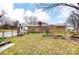 View of brick ranch home with patio in a leafy backyard, with a partial fence and various plants at 9534 Markus Dr, Mint Hill, NC 28227