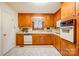 Well-maintained kitchen featuring wood cabinets, white appliances, and a functional layout at 9534 Markus Dr, Mint Hill, NC 28227
