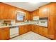 Functional kitchen with wood cabinetry, white appliances, and a window over the sink at 9534 Markus Dr, Mint Hill, NC 28227