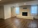Finished basement with luxury vinyl plank flooring, a brick fireplace, and stairs to the upper level at 100 Chadmore Dr, Charlotte, NC 28270